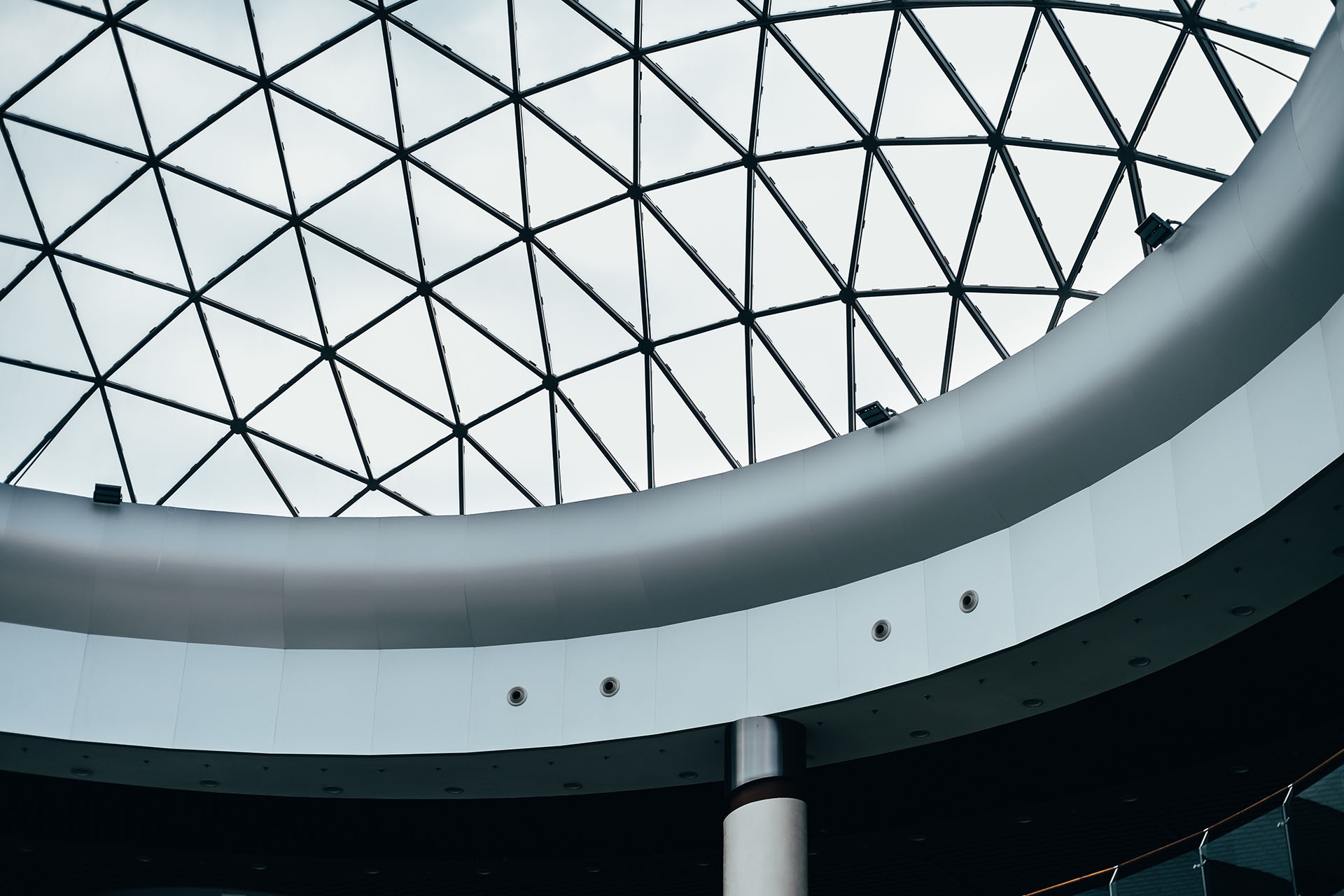 Fragment of glass dome made of metal triangular structures. Inside view from bottom.